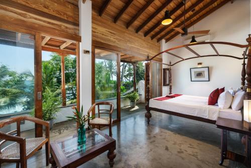 1 dormitorio con 1 cama y 1 mesa en Royal Indigo Villa en Talpe