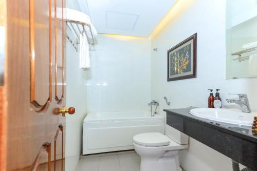 ein Badezimmer mit einem weißen WC und einem Waschbecken in der Unterkunft Paradis Hotel Quy Nhon in Quy Nhon