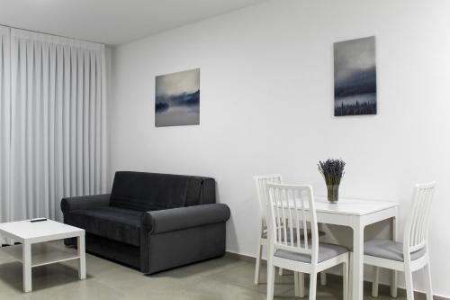 ein Wohnzimmer mit einer Couch und einem Tisch und einem Stuhl in der Unterkunft Luxury Suite Apartment #60 By Hashdera Eilat in Eilat