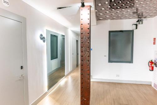 um quarto com uma ventoinha de tecto e um corredor em Hostal Juliette-Gran Vía em Madri