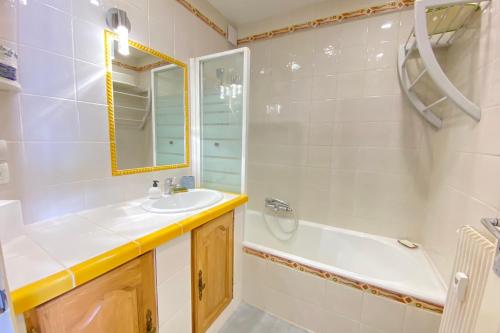 une salle de bain avec un lavabo, une baignoire et un miroir dans l'établissement 06BP - Beautiful 6-person apartment in Valberg, à Valberg