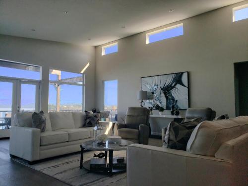 a living room with couches and a table and windows at EdgeWater Chemainus in Chemainus
