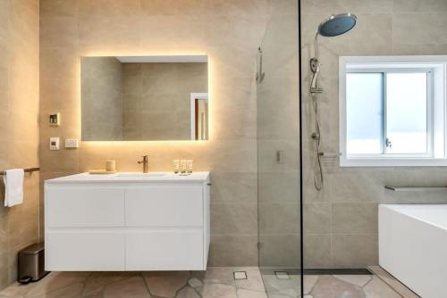 een badkamer met een witte wastafel en een douche bij Cosy & Modern Mountain Getaway Katoomba in Katoomba