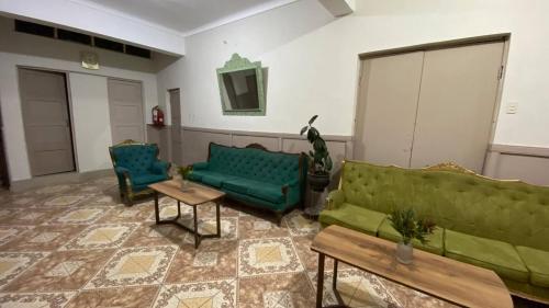 a living room with two green couches and a table at Templo de la Luna in Cusco