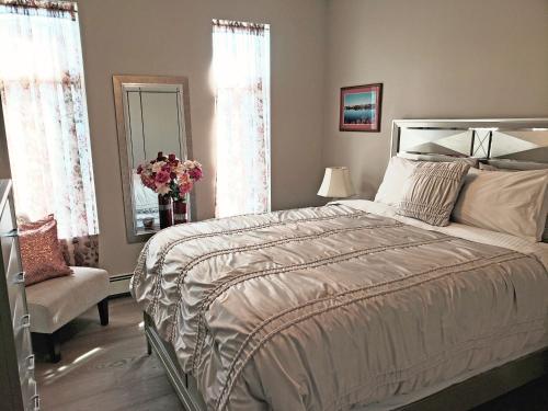 a bedroom with a bed and a chair and a mirror at EdgeWater Chemainus in Chemainus