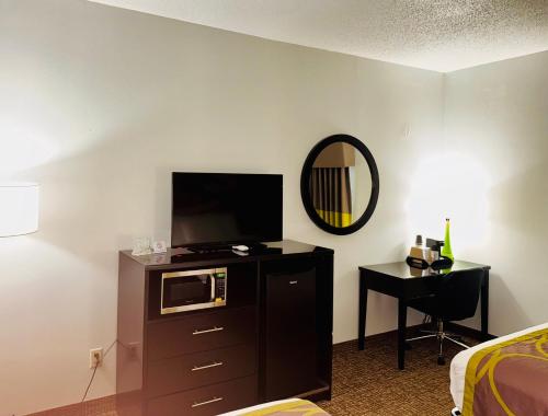 a hotel room with a microwave and a mirror at Forest City Inn in Forest City