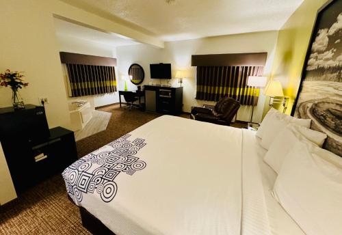a hotel room with a large bed and a desk at Forest City Inn in Forest City