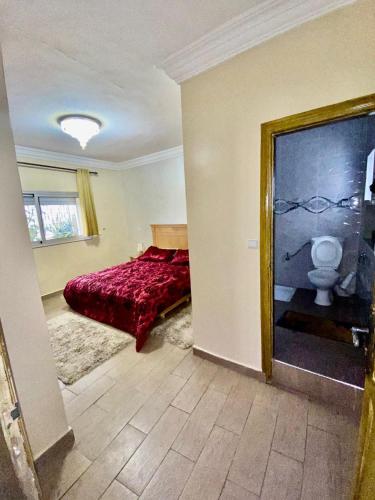 Lilya Villa sabllete front de la mere في المحمدية: غرفة نوم بسرير احمر ومرحاض