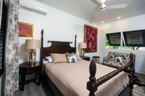 a bedroom with a bed and a chair at Tardis Rose Cottage w/rental vehicle access in Cap Estate