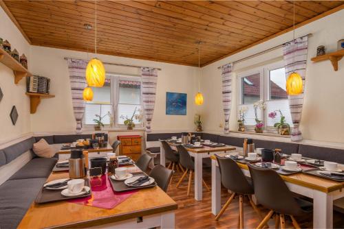 a restaurant with wooden ceilings and tables and chairs at Pension Bayerwald in Bodenmais