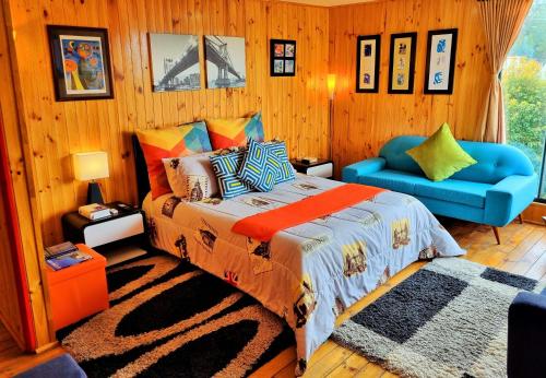 グアタビータにあるEl Remanso Guatavita - Casa Campestre Completaのベッドルーム1室(ベッド1台、青い椅子付)