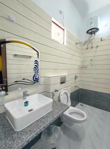 a bathroom with a sink and a toilet at Hotel Hill River View Resort in Uttarkāshi