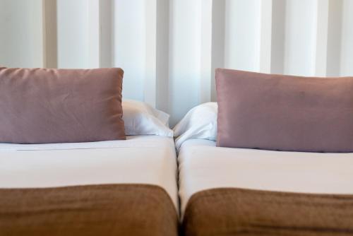 a couch with two pillows on top of it at Hostal Charlotte-Gran Vía in Madrid