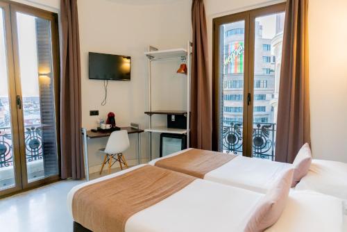 um quarto de hotel com uma cama e uma varanda em Hostal Charlotte-Gran Vía em Madrid