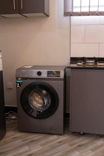 a washing machine in a kitchen next to a counter at Serene Homes 02 in Kampala