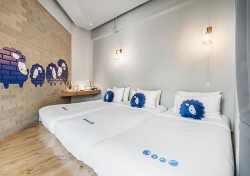 曼谷的住宿－曼谷素里翁可可特爾酒店，卧室配有一张白色大床,上面有蓝色填充动物