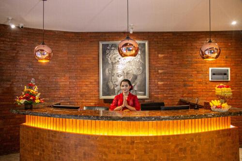 una mujer sentada en un bar en un restaurante en djabu Seminyak Hotel, en Seminyak