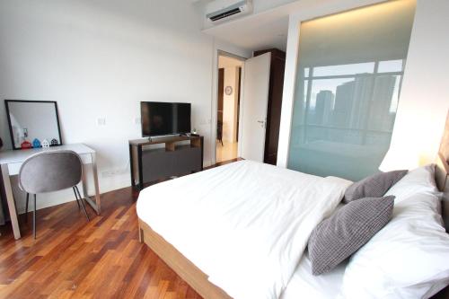 a bedroom with a bed and a desk and a television at Grand Medini 3 mins drive Legoland in Nusajaya
