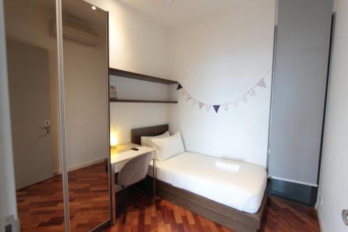 a small bedroom with a bed and a mirror at Grand Medini 3 mins drive Legoland in Nusajaya