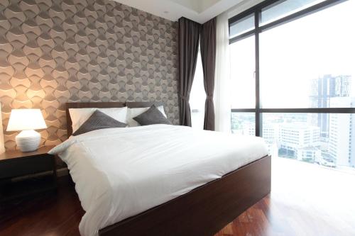 a bedroom with a large bed and a large window at Grand Medini 3 mins drive Legoland in Nusajaya