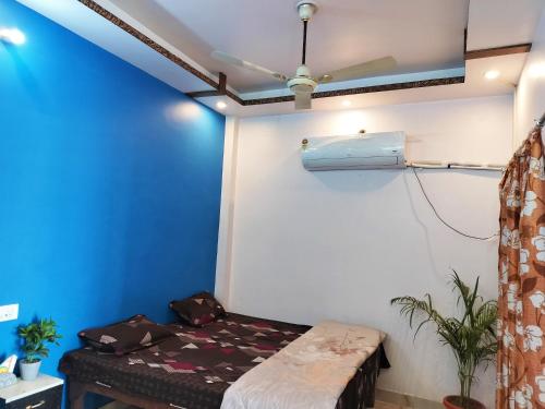 Habitación con cama y pared azul en Youg Homestay, en Faizābād