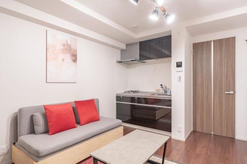 a living room with a couch and a kitchen at Art Nagara in Osaka