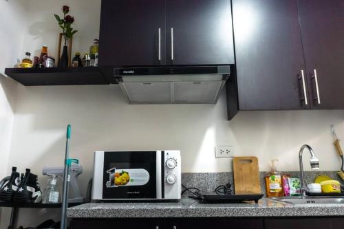 a kitchen with a counter top with a microwave at Luxury Resort Condo in Pasig FastWifiPoolSmartLock in Manila