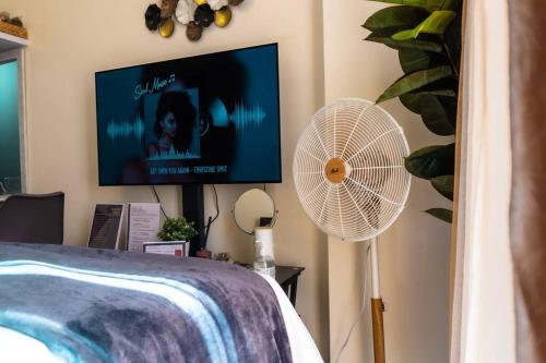 マニラにあるFlexi-Living Premium Condo in Kasaraのベッドルーム(テレビ、ファン、ベッド付)