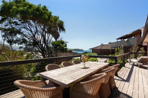 a wooden table and chairs on a deck at Breeze on Barclay in Gerringong