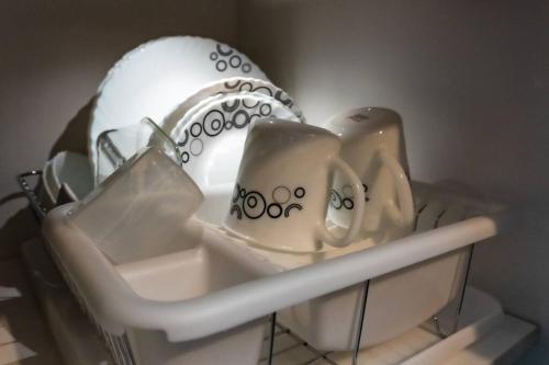 a shelf with cups and a plate and a ball at Luxury Resort Condo in Pasig FastWifiPoolSmartLock in Manila