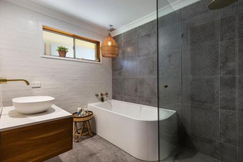 uma casa de banho com uma banheira e um lavatório em Breeze on Barclay em Gerringong