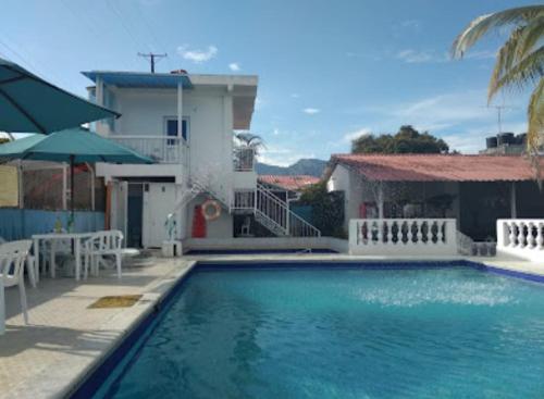 a swimming pool in front of a house at Hotel Villa Gloria in Melgar