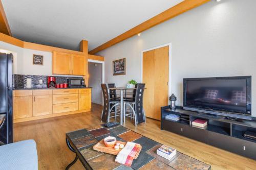 a living room with a large television and a table at Charming Condo - European Vibe in Palm Coast