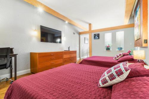 a bedroom with two beds and a dresser with a tv at Charming Condo - European Vibe in Palm Coast