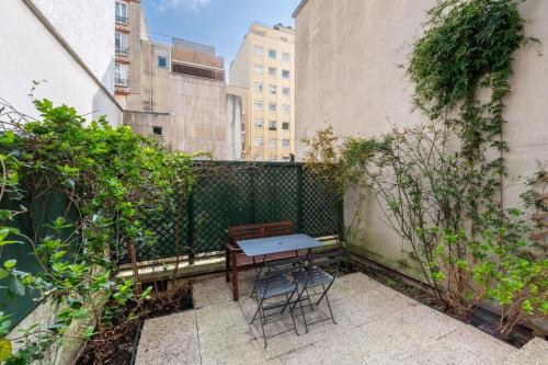 un patio avec une table et des chaises sur un balcon dans l'établissement Urban & Stylish Apartment w GardenNation, à Paris