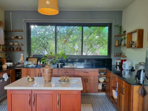 a kitchen with a large window and a table with a plant at Comfy Riverside Mekong homestay Ben Tre in Ấp Phú Hòa (3)
