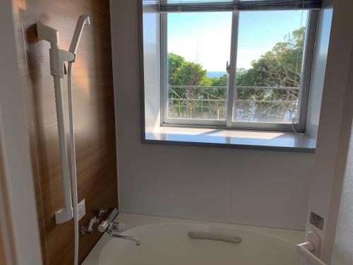 een badkamer met een douche, een raam en een wastafel bij HOTEL HOLISTIC RESORT - Vacation STAY 34549v in Taiji