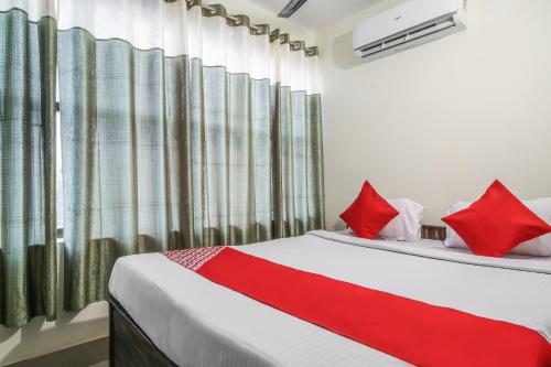 a bedroom with two beds with red pillows at Hotel O Lokenath in Jamshedpur