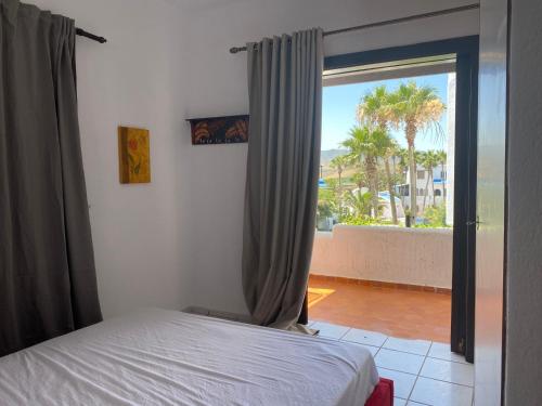 a bedroom with a bed and a sliding glass door at Bahia Smir et Al Amin Plage Front mer in Fnidek