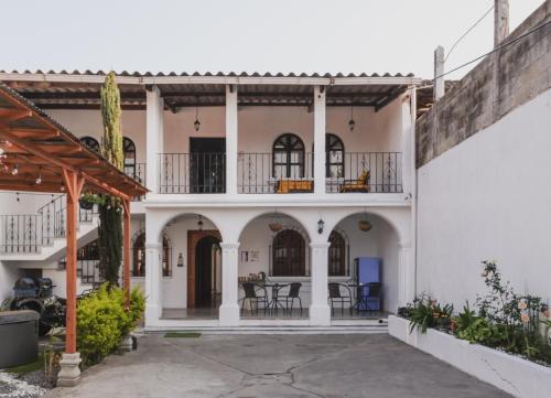 a house with white walls and a courtyard at Blue Moon Hostel in Antigua Guatemala