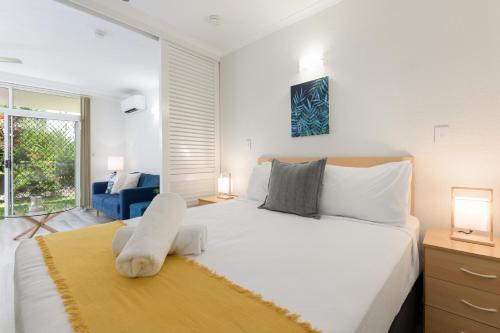ein Schlafzimmer mit einem großen weißen Bett und einem Fenster in der Unterkunft 1 Bedroom @ Palm Villas #3 in Port Douglas