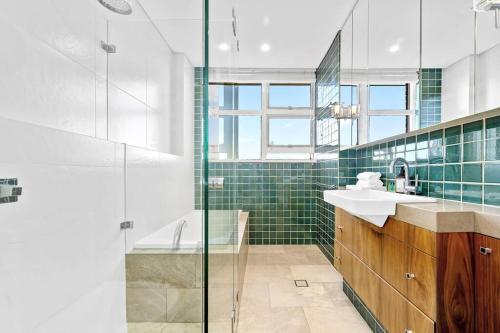 La salle de bains est pourvue d'une douche, d'un lavabo et d'une baignoire. dans l'établissement Sydney's Landmark Views from Luxury 2Bd Apt, à Sydney