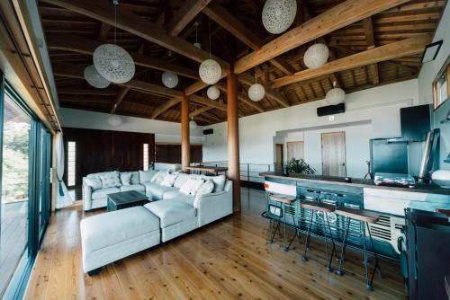 a living room with a white couch and a kitchen at Villa CHINENBLUE 日常を忘れコバルトブルーの海と過ごす究極の休日 in Kudeken