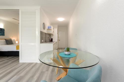 a glass table in a room with a bedroom at 1 Bedroom @ Palm Villas #3 in Port Douglas
