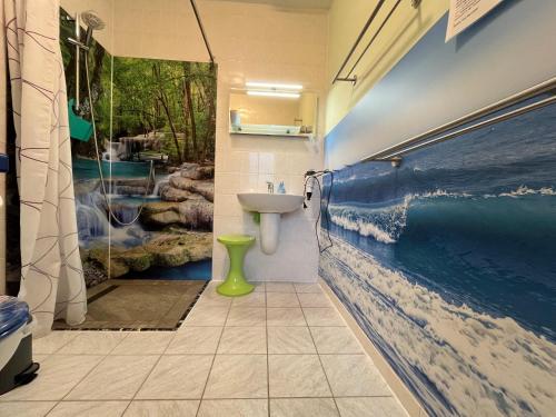 a bathroom with a painting of the ocean on the wall at Apartment Mahlke in Stedar