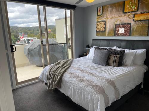 a bedroom with a bed and a balcony at Qbn Cracker: 2BR, 2BA, 2 secure b/ ment car parks in Queanbeyan