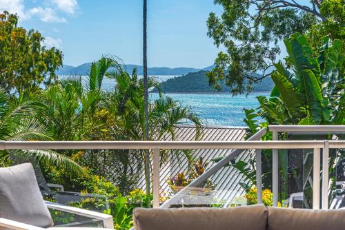 a balcony with chairs and a view of the water at Blue Water Views on Hamilton Island by HIHA in Hamilton Island