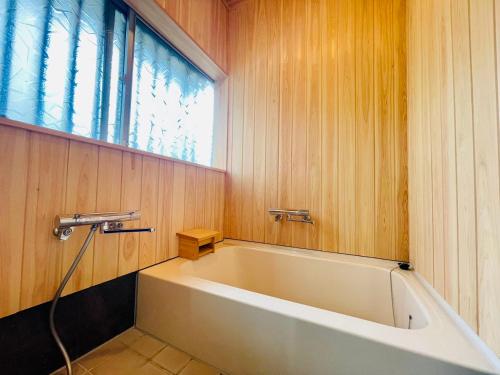 a bath tub in a bathroom with a window at NEW OPEN『天然温泉』芦ノ湖畔の完全貸切別荘 in Hakone