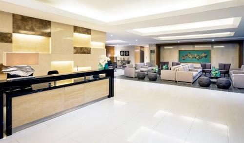 a lobby of a hotel with couches and chairs at Condo Near MOA, NAIA, PICC, & CCP that is comfy with a view! in Manila