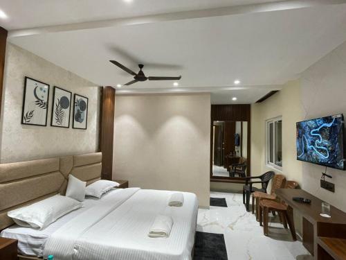 a bedroom with a bed with a ceiling fan at Hotel Narmada Residency in Sambalpur